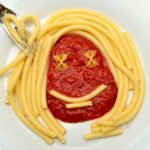 A pasta dish with a smiley face